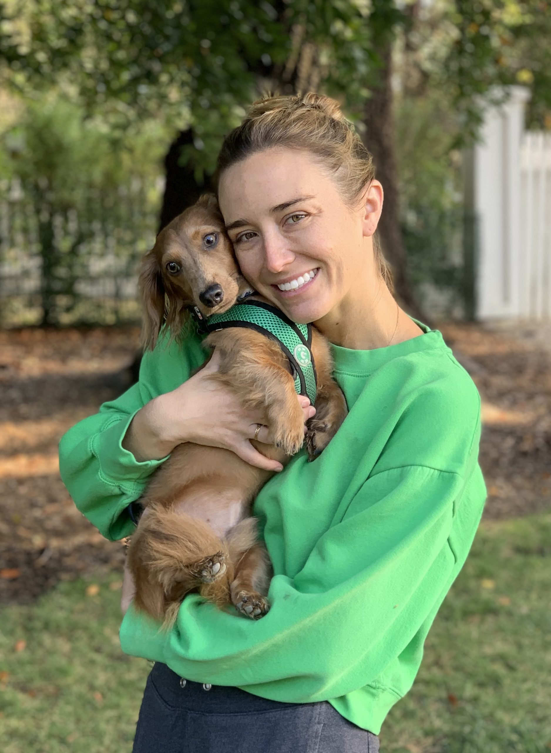 closeup shot of a woman in green shirt with a dog
